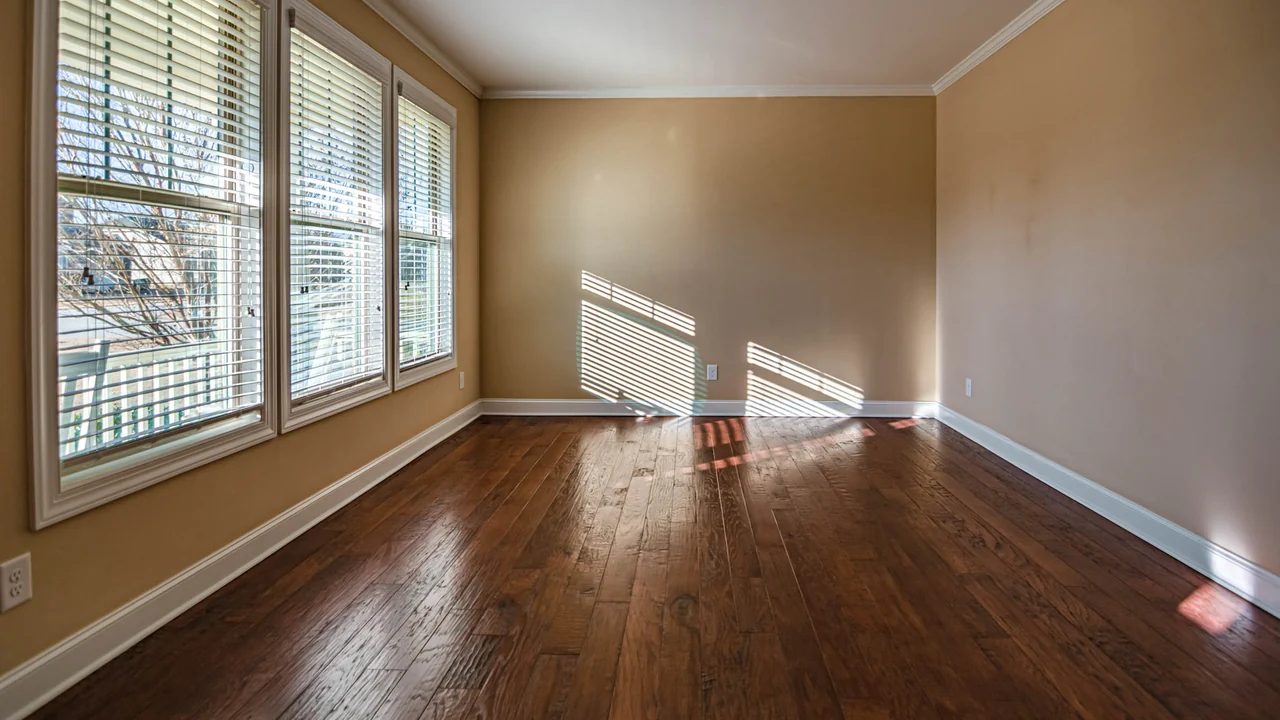 An empty room in St. Petersburg with new dark hardwood flooring laid straight to the walls